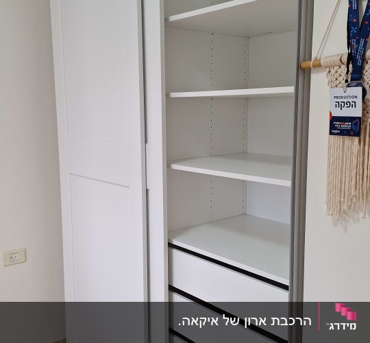 ארון לבן עם מדפים ודלת פתוחה